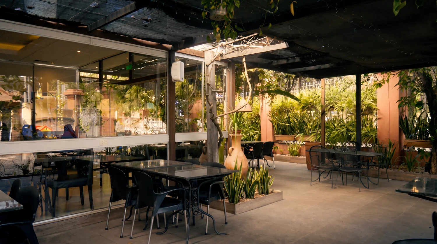 Terraza con pérgola y mesas servidas